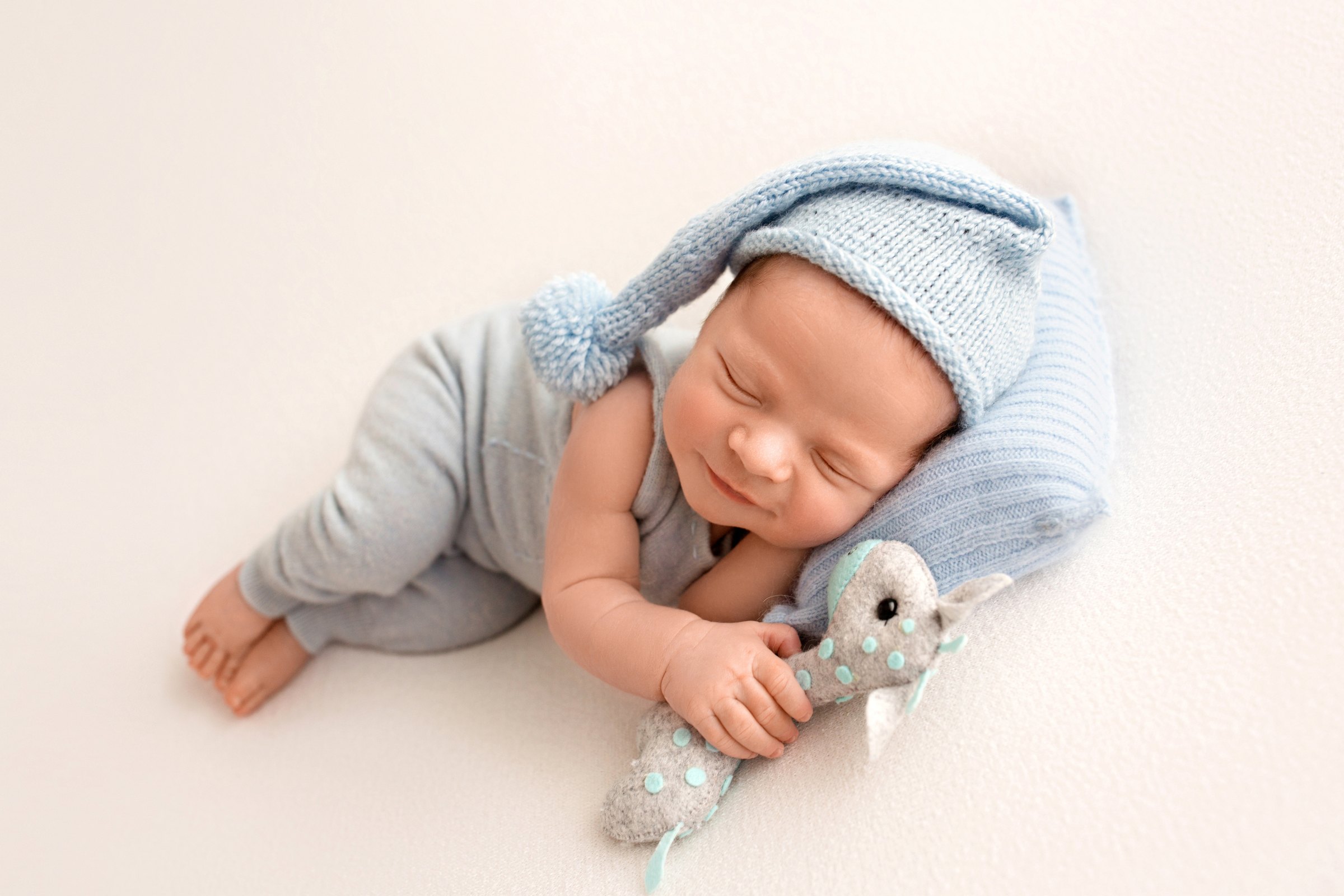 Sleeping newborn in a blue knit hat